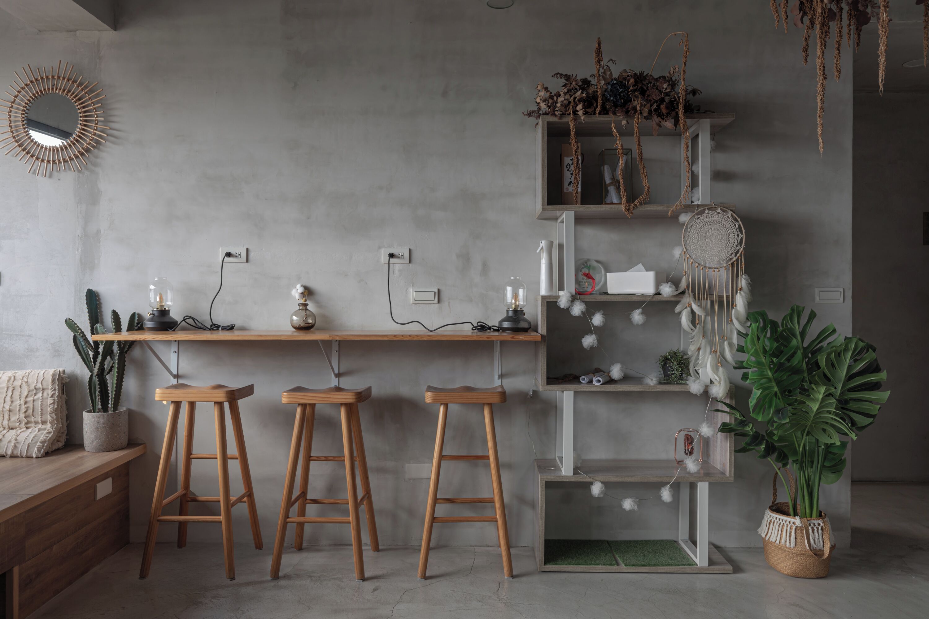 Een moderne keuken met houten krukken, een hanger met een dreamcatcher en een potplant.