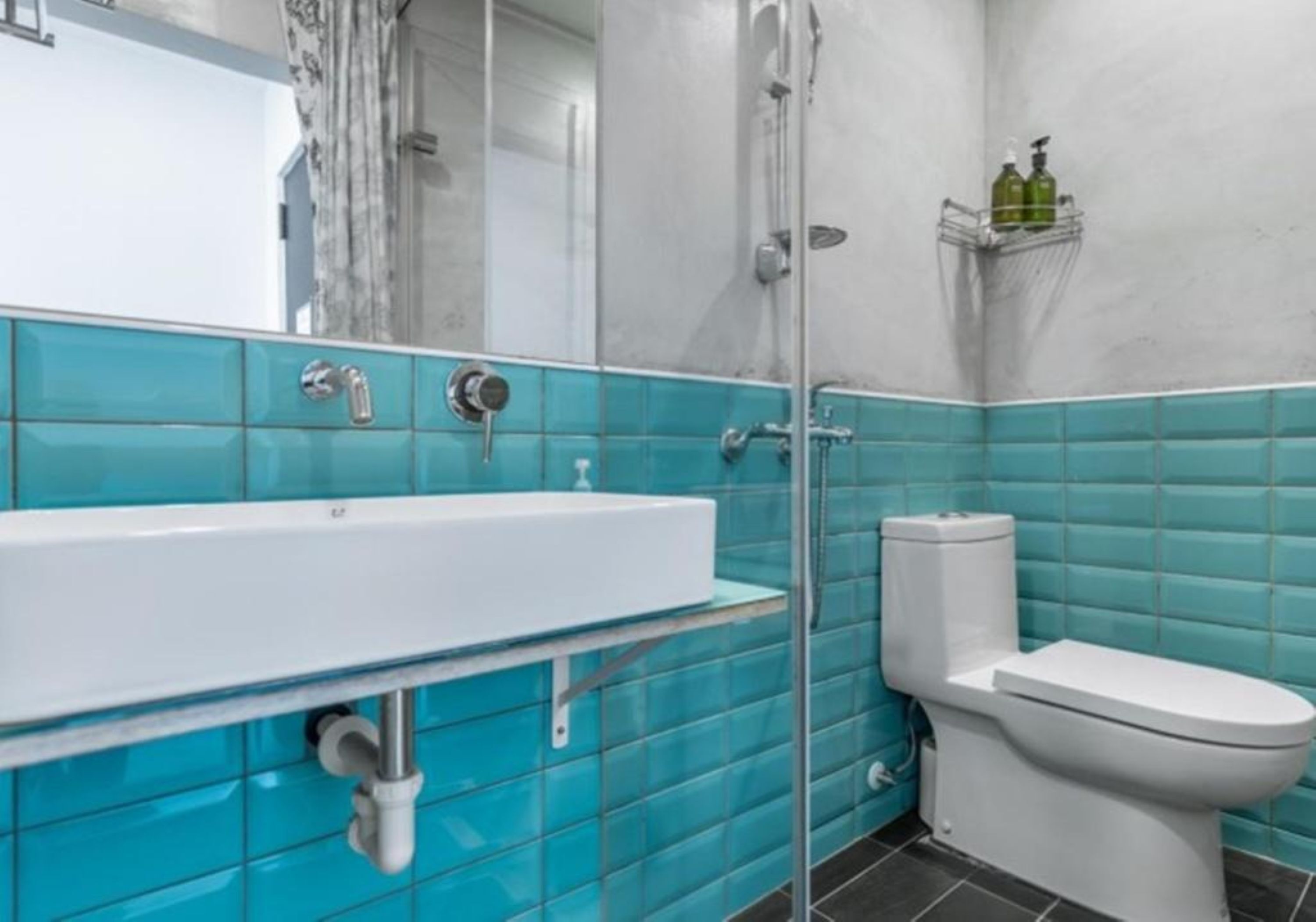 A bathroom with a white sink, a toilet, and a shower.