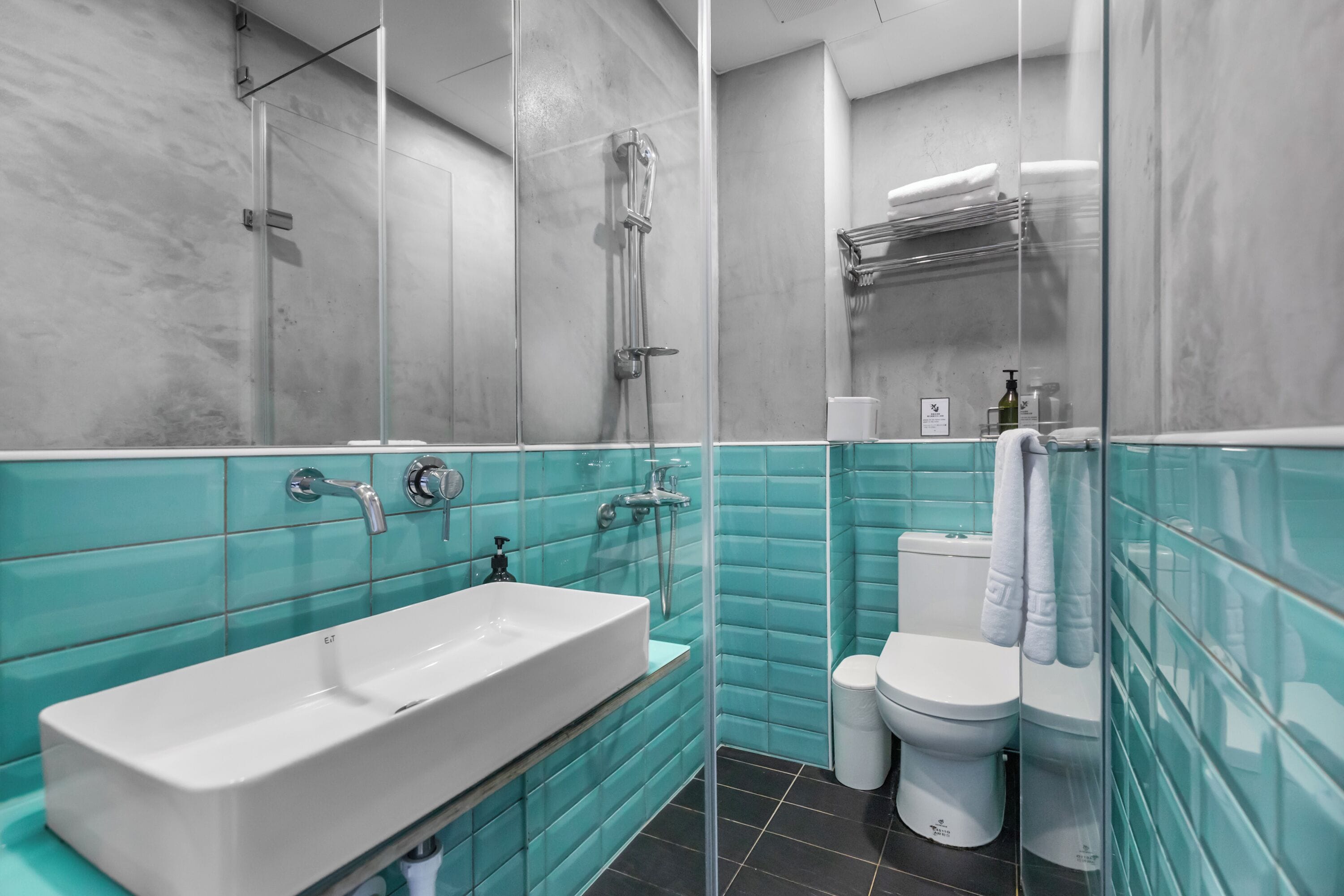 A bathroom with a white sink, a glass shower enclosure, and a toilet.