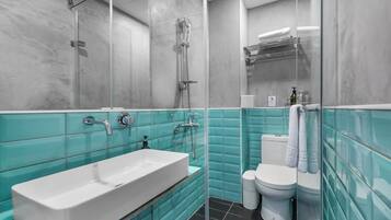 A bathroom with a white sink, a glass shower enclosure, and a toilet.