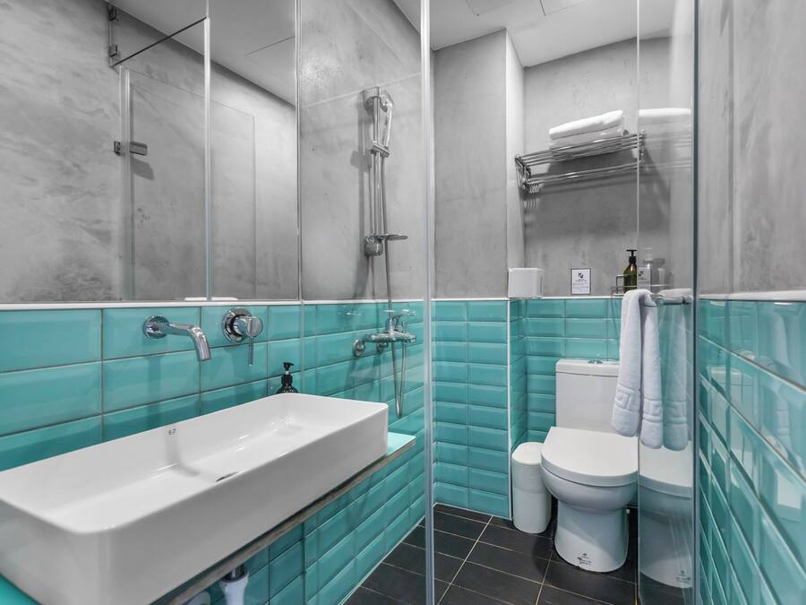 A bathroom with a white sink, a glass shower enclosure, and a toilet.
