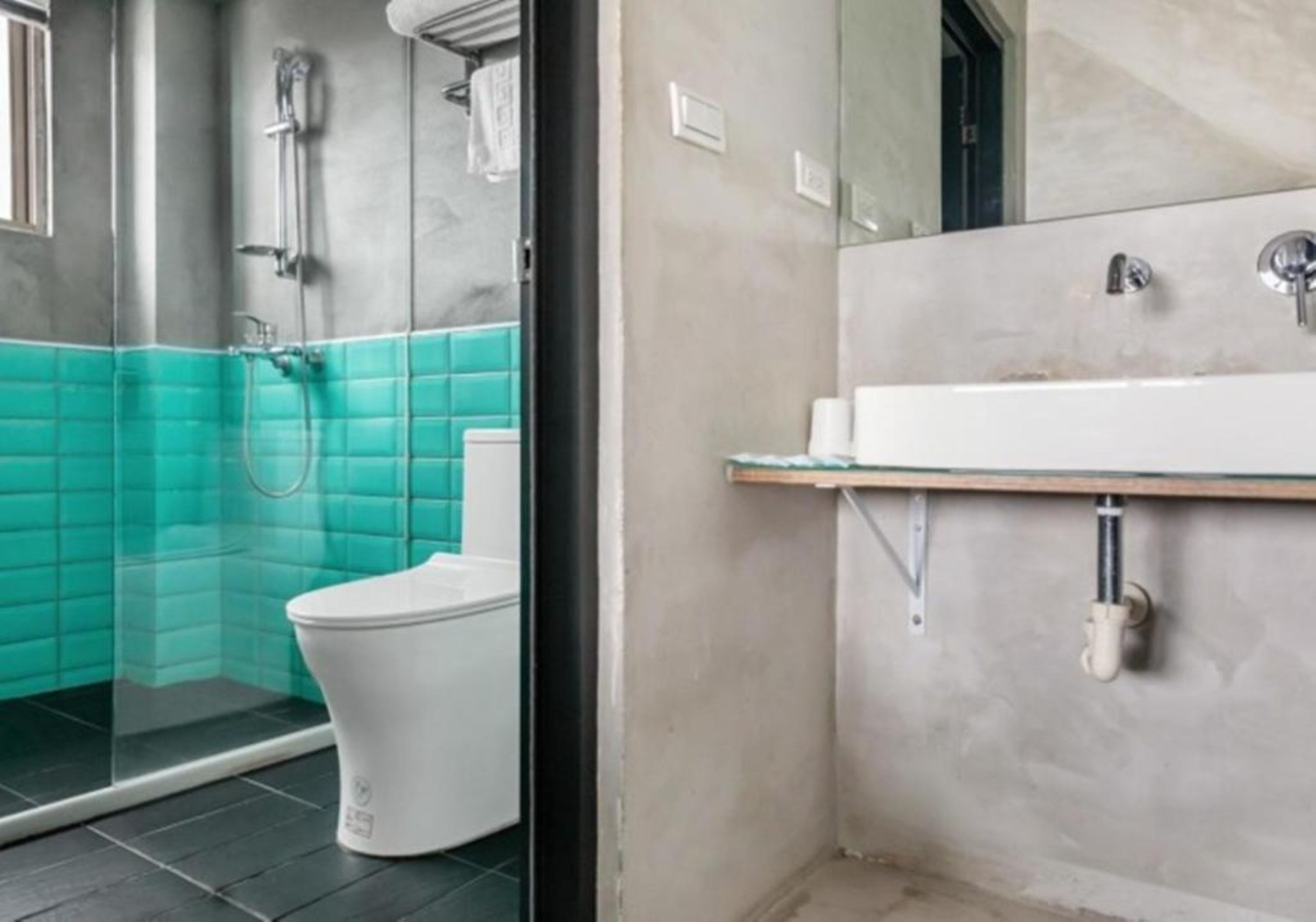 A modern bathroom with a glass shower enclosure, a white toilet, and a sink with a mirror above it.