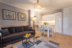 Un salon moderne comprenant un canapé, une table à manger et un coin cuisine.
