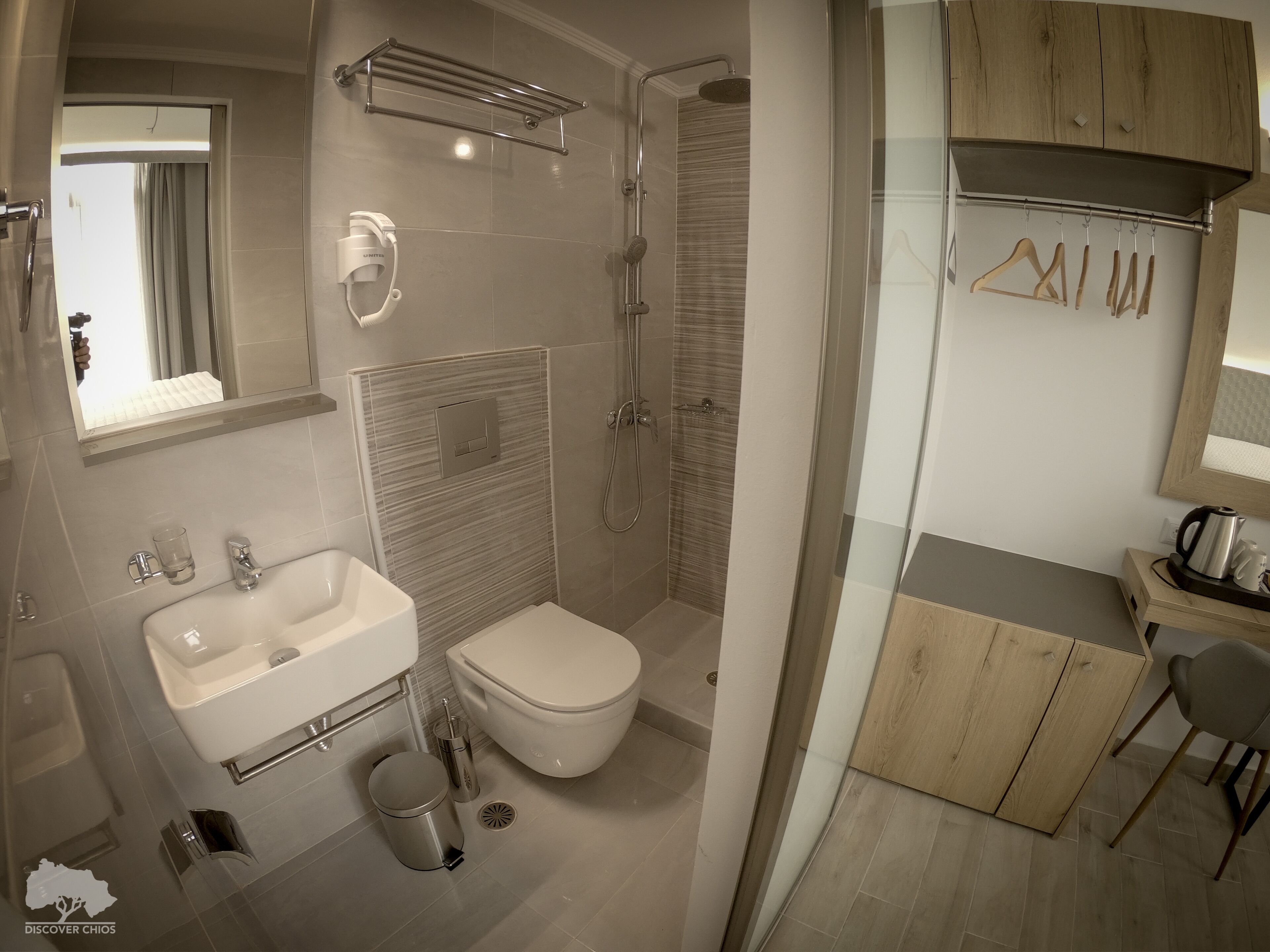Un baño moderno con ducha, inodoro, lavamanos y zona de tocador con cristal.