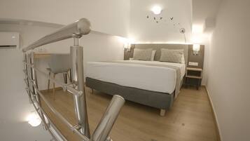 Una habitación de hotel moderna con una cama grande, un escritorio y una escalera.