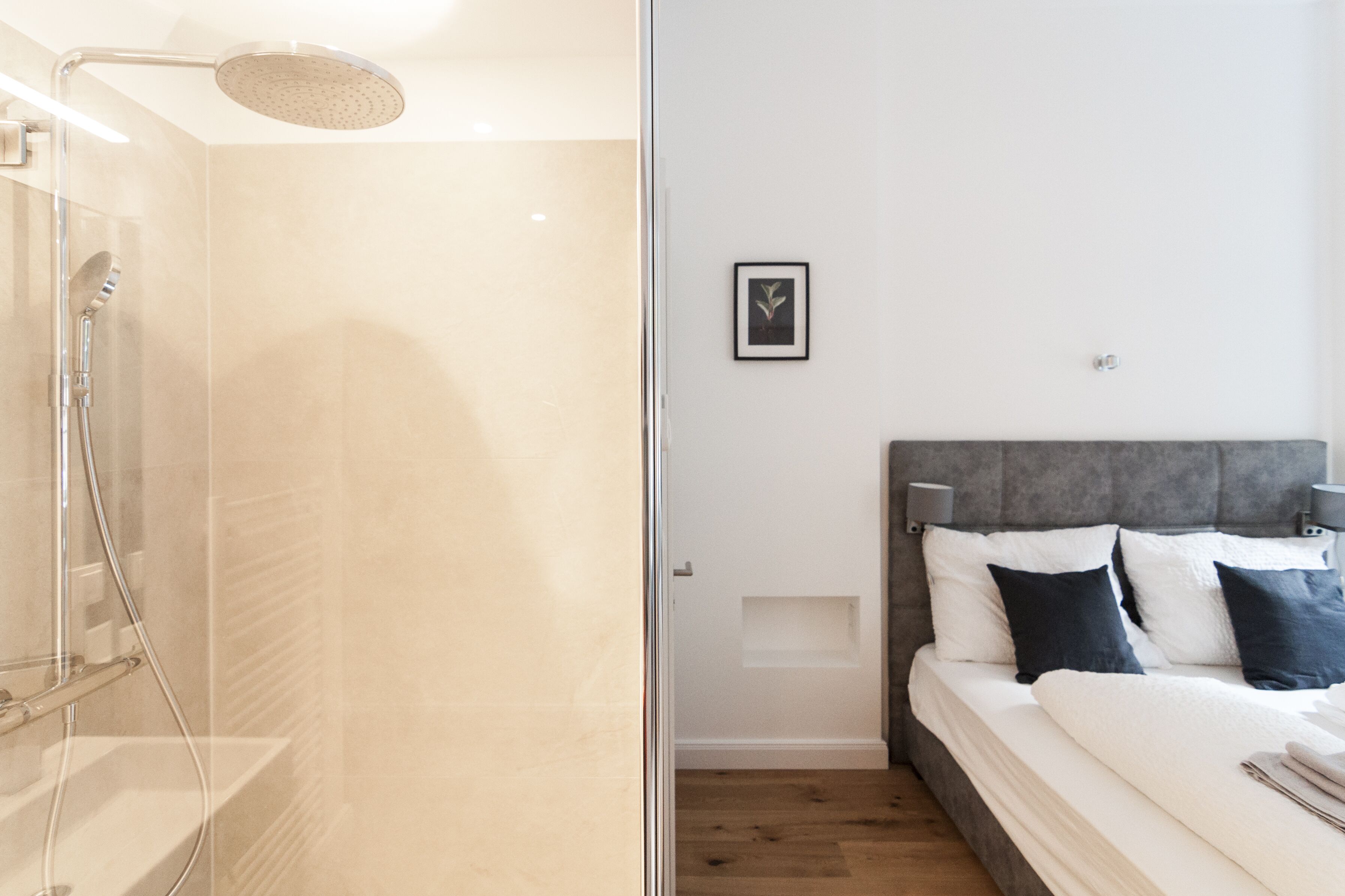 A modern bathroom with a glass shower enclosure and a separate showerhead.