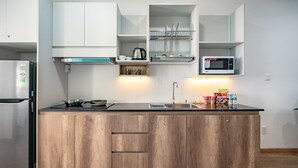 A modern kitchen with wooden cabinets, a stainless steel refrigerator, a microwave, and a built-in oven. - The Sea House Nha Trang (Nha Trang)