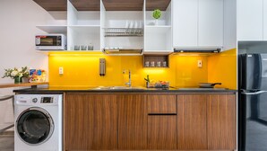 A modern kitchen with a built-in washer, a microwave, and a refrigerator. - The Sea House Nha Trang (Nha Trang)
