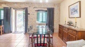 A dining area with a glass table, chairs, and a wooden cabinet. - La Rajoleria d'Esclanyà, rural house with private swimming pool on the Costa Brava (esclanyà)