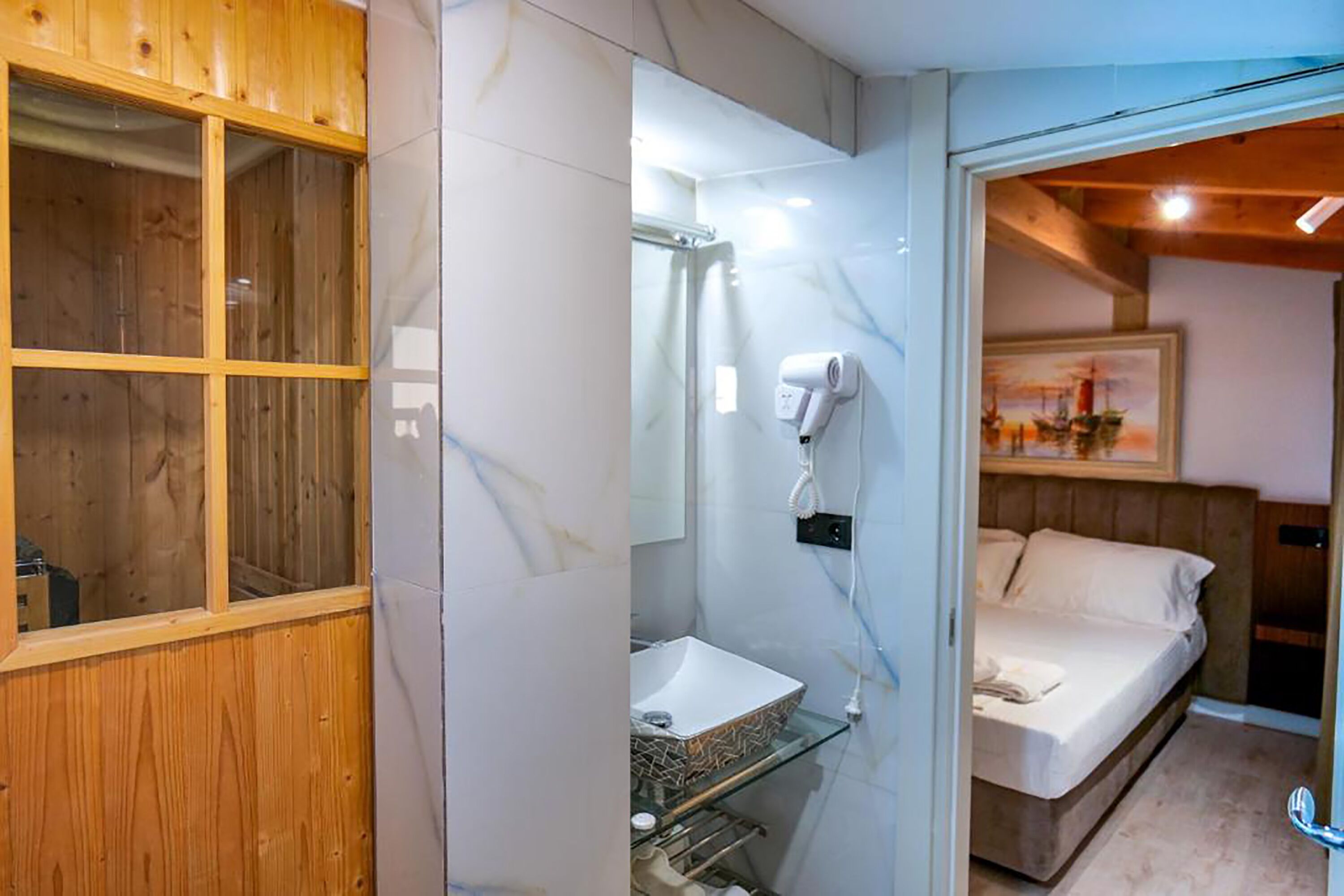 A bathroom with a wooden vanity, a glass sink, and a shower area.