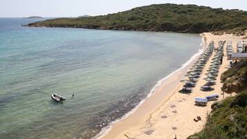 Nära stranden, vit sandstrand och solstolar