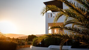 A modern building with a white facade, arched windows, and a flat roof. - Villa Maniati Studios (Andros)