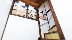 A wooden staircase with traditional Japanese artwork on the walls. - Tokyo House (Tokyo)