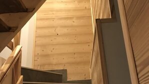 Un escalier en bois mène à une pièce dont le plancher est également en bois.
