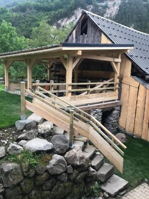 Une structure en bois avec une base en pierre, un pont en bois et un toit en métal.
