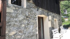 Un bâtiment en pierre avec une porte en bois et une antenne parabolique.