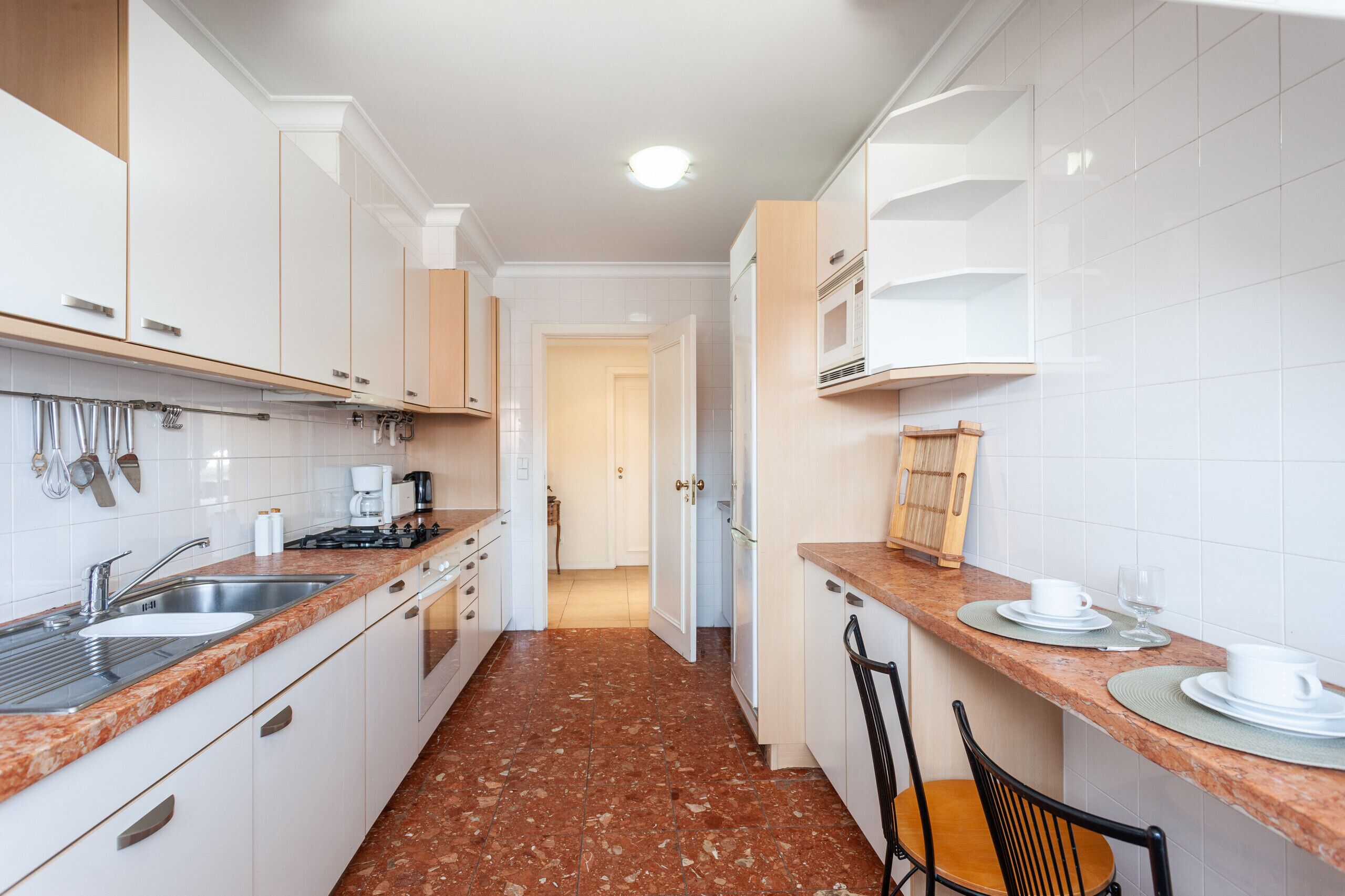 A modern kitchen with white cabinets, granite countertops, and a tiled backsplash.