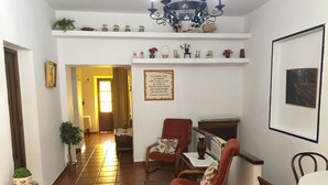 Una sala de estar acogedora con chimenea, un comedor con mesa y sillas, y un pasillo que lleva a otra habitación.