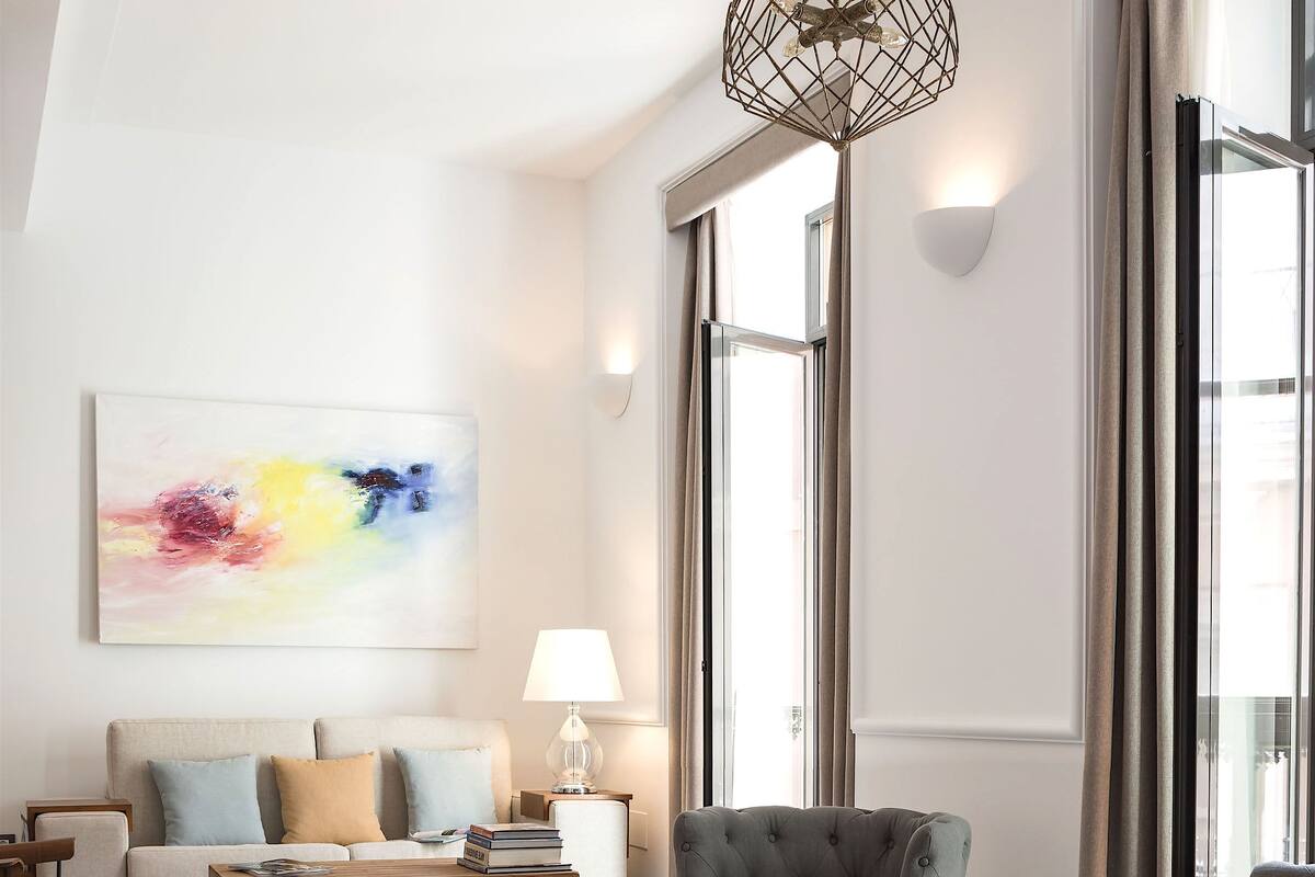 A modern living room with a sofa, armchairs, a coffee table, and a record player.