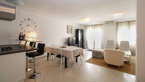 A modern living room with a dining area, a TV, and a cabinet. - House 1581/16219 (Istria - Valbandon), 2250m from the beach (Valbandon)