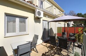 A patio with a table and chairs, an air conditioning unit, and a red fence. - House 1581/16219 (Istria - Valbandon), 2250m from the beach (Valbandon)