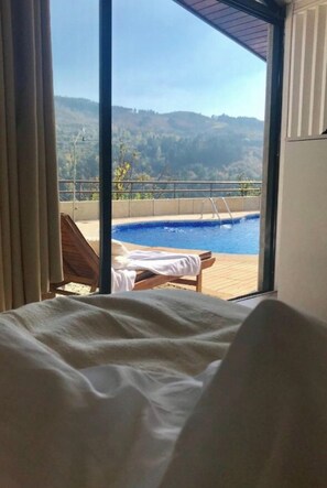 A bedroom with a view of a swimming pool and hills. - Pedacinho de Mundo Douro (Marco de Canaveses)