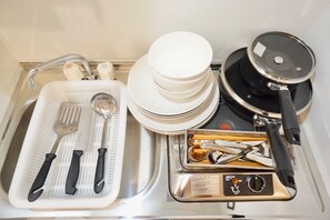 A kitchen with a sink, a dish rack, a stove, and a tray of utensils. - Hostel 758 Nagoya2H (Nagoya)