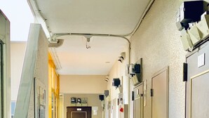 En gang med døre på begge sider, en brandslukker og en dør med påskriften '1K'.