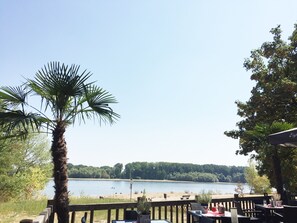 A lakeside patio with outdoor seating and a view of the lake. - Oppenheim Lofts (Oppenheim)