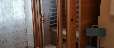 Una habitación con un armario de madera, una pequeña silla y una alfombra mullida.