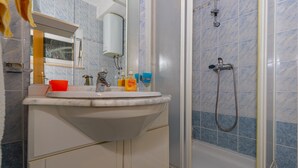 A bathroom with a sink, mirror, and shower. - Apartment Dadi (Crikvenica)