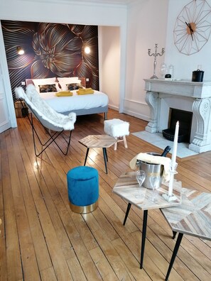 A modern living room with a bed, a fireplace, and a decorative wall. - B&B 43 4 (Le Puy-en-Velay)