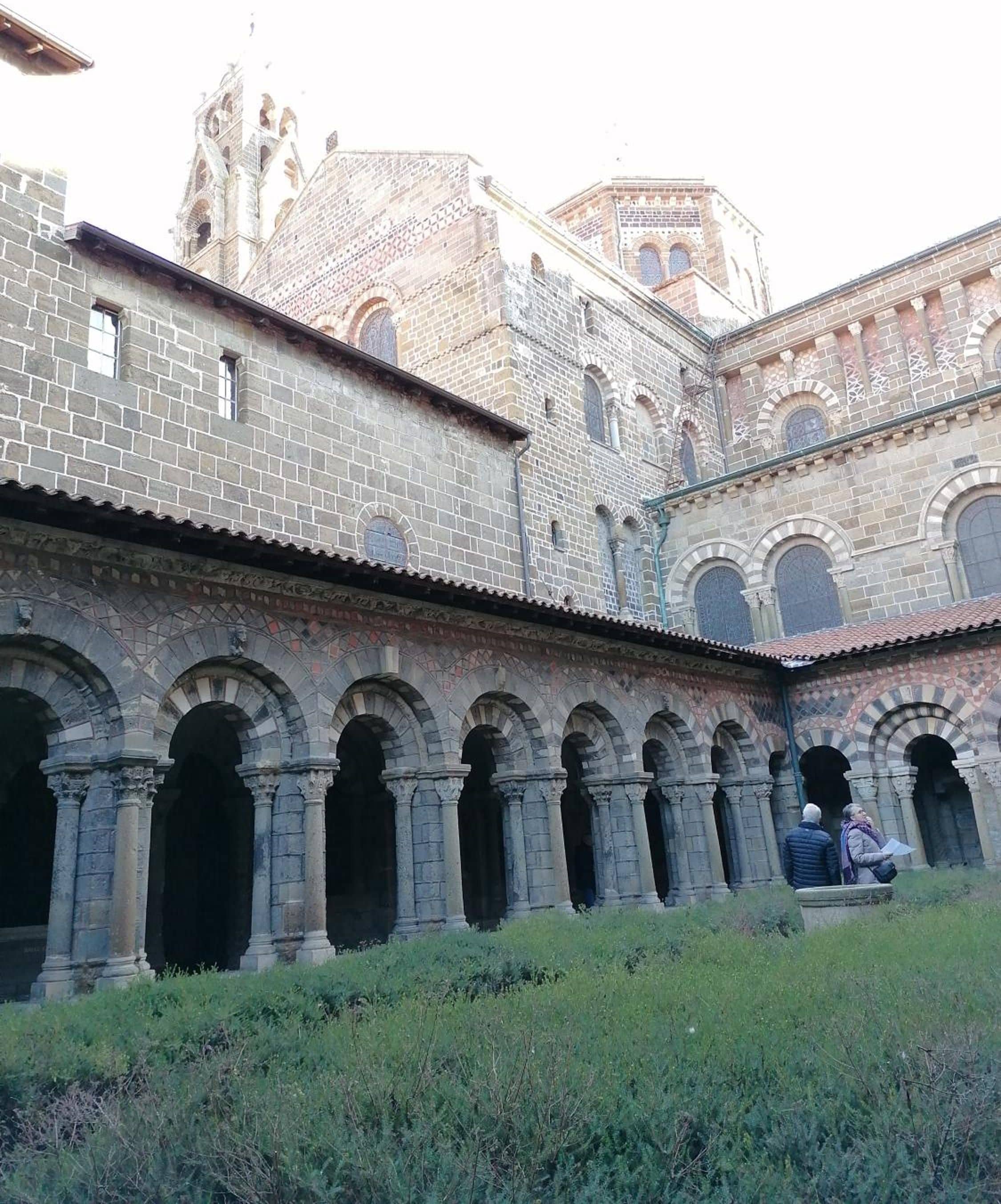 Un bâtiment historique doté d’une cour intérieure, caractérisé par une série d’arcades et une tour imposante.