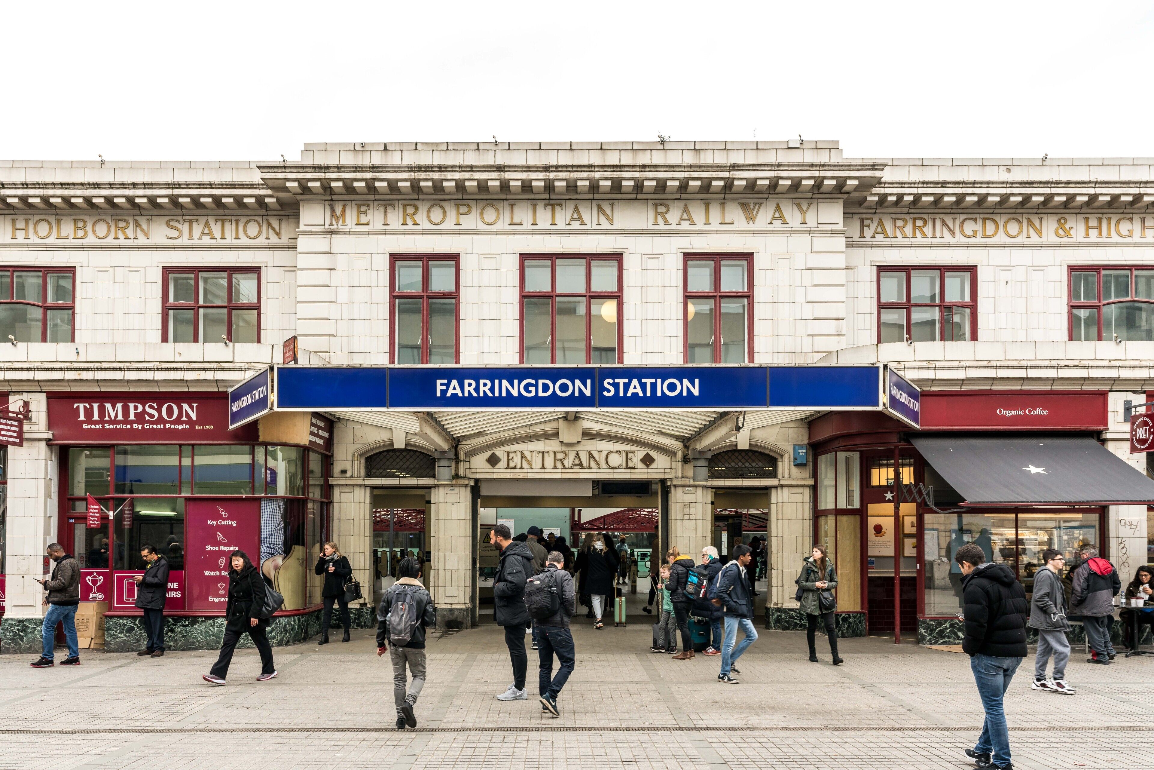 Ein Bahnhofsportal mit mehreren Bahnsteigen und einem deutlichen Schild für Farringdon Station.