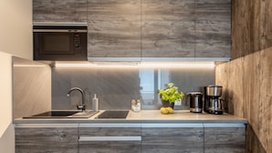 A modern kitchen with wooden cabinets, a built-in microwave, a sink, and a coffee maker. - Vacation apartment by the sea, vacation on the island of Usedom, Apartment AURORA (Świnoujście)