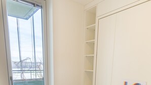 A dining area with a white table set for four, white chairs, and a 'LOVE' sign on the wall. - easy-flat Grüner Prater - Balcony Apartments near Metro (Vienna)
