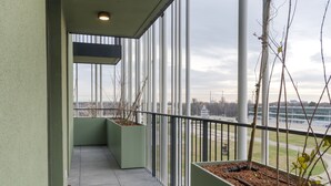 A corridor with a view of a sports field and a building in the distance. - easy-flat Grüner Prater - Balcony Apartments near Metro (Vienna)
