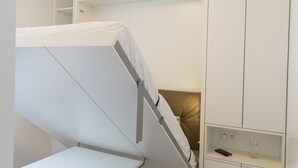 A compact room with a bunk bed, built-in storage, and a ceiling light fixture. - easy-flat Grüner Prater - Balcony Apartments near Metro (Vienna)