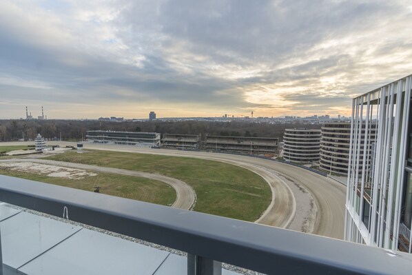 A view of a racetrack with a large building complex in the background. - easy-flat Grüner Prater - Balcony Apartments near Metro (Vienna)