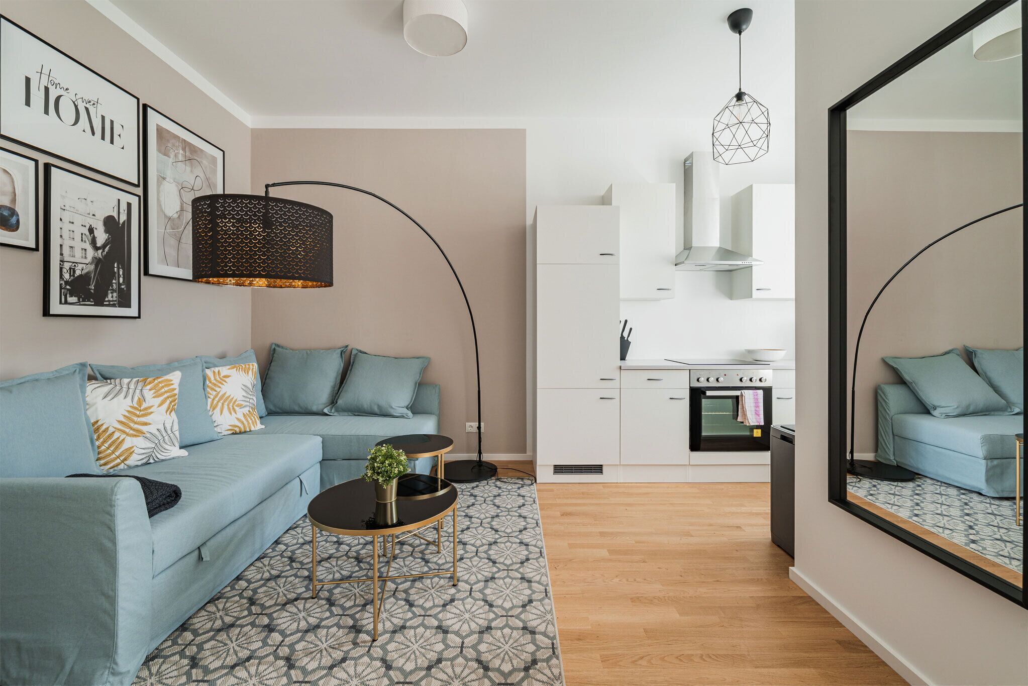 A modern living room with a sofa, coffee table, and a kitchen in the background.