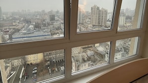 Une pièce dotée d’une grande fenêtre donnant sur un paysage urbain.