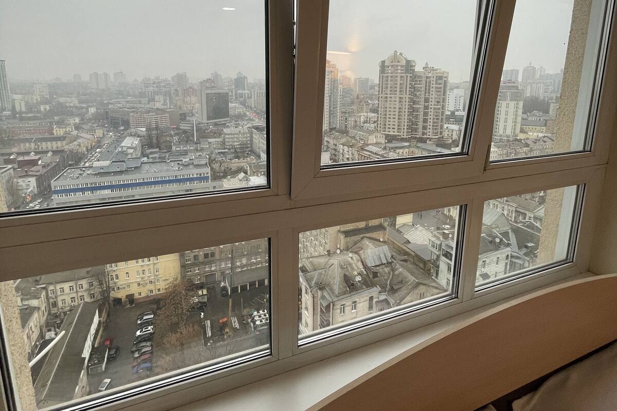 Una habitación con un gran ventanal con vistas a un paisaje urbano.