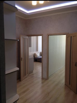 Ein Zimmer mit Holzschrank, Bett mit Kopfteil und einer Schiebetür.
