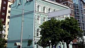 Un immeuble de grande hauteur doté de nombreux balcons et d’une structure moderne en verre qui y est adossée.