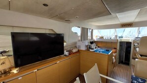 Een kleine kombuis met een groot flatscreen-televisie, een koffiezetapparaat en een klein spoelbakje.