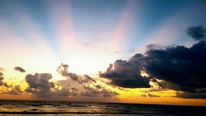 Un atardecer sobre el océano con nubes.