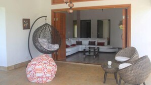 A modern living area with a hanging chair, a patterned ottoman, and wicker chairs. - CERRITOS ... NATURE, BEAUTY AND FUN !! (Pereira)