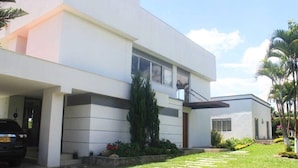A modern two-story house with a covered driveway, a car parked in the driveway, and a well-maintained lawn. - CERRITOS ... NATURE, BEAUTY AND FUN !! (Pereira)