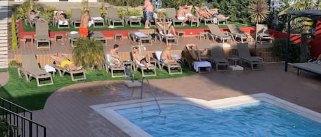 A pool area with lounge chairs and a swimming pool.