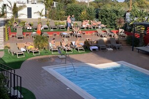 Un área de piscina con sillones de descanso y una piscina.